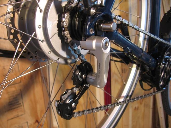 A common design goes on the internally-threaded lug normally used by a derailleur, and looks very similar to a derailleur but doesn t move laterally.