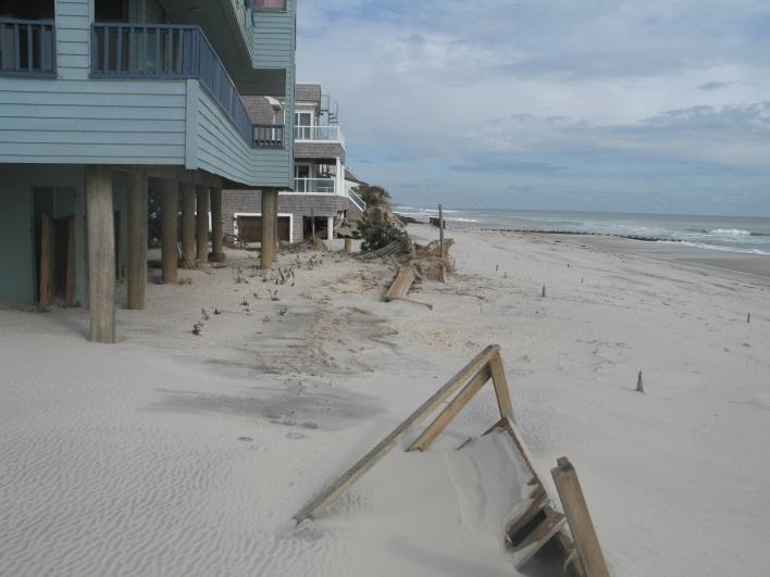 In the photo on the right taken on November 2, 2012 from a similar location looking south post Sandy the impact of the storm is evident the dune seaward of the homes is obliterated the beach is lower