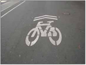 It was found that the markings increased the safety margin for bicyclists riding near the curb. Additionally, sidewalk riding decreased. (4) Figure. Photo. Bike-in-house marking.