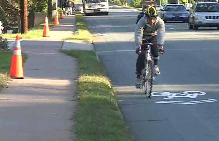 Figure 5. Photo. Bicyclist riding next to the sharrow in the inbound (uphill) direction.