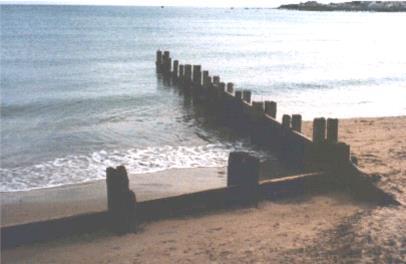 Examination question 38 of 43 Study the photograph of Swanage Beach. What is longshore drift?