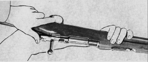 Place the firing pin against a non-damaging surface. Place the thumb over the safety (in its middle position) and press the bolt cover downwards as far as it will go. 5.