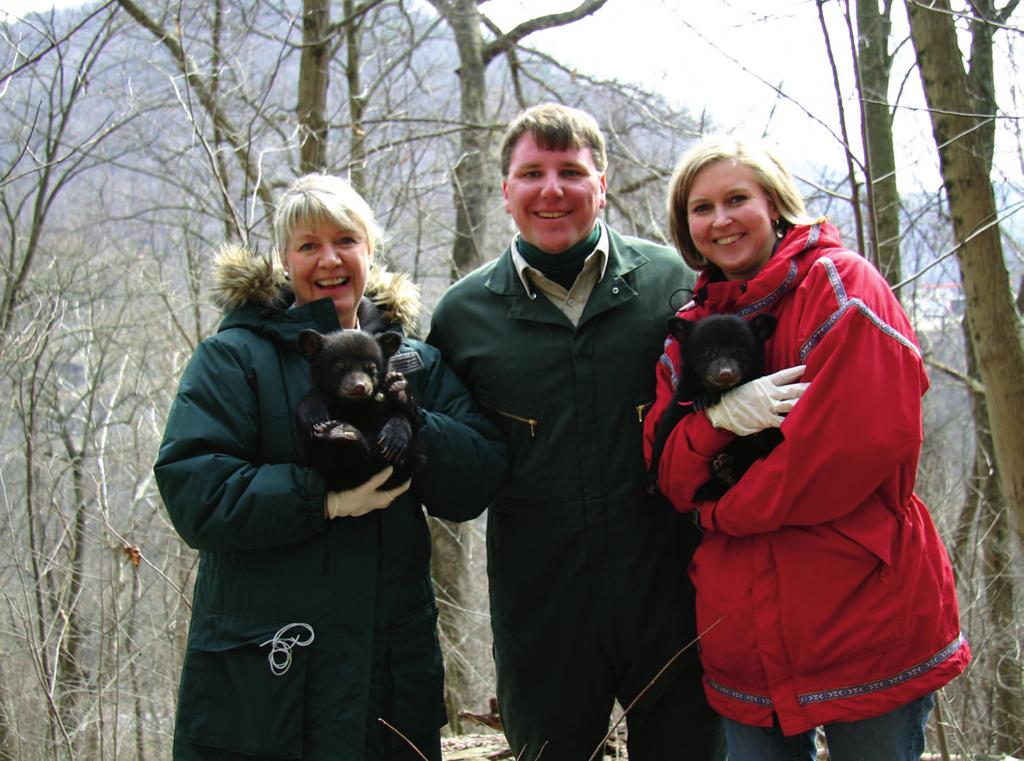 Chris Ryan, supervisor of game management services for the Division of Natural Resources, is joined by his aunt Jeanne Wooten, left, and wife Beth Ryan during a visit to a bear den.
