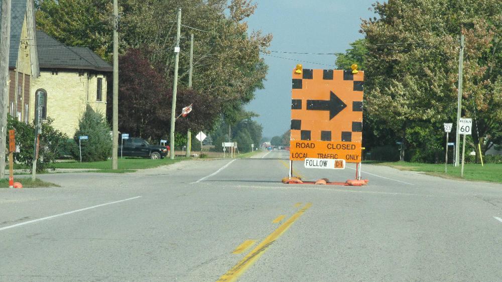 A road closure sign exists at the intersection.