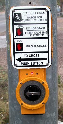 Traffic Signals Other Considerations: Signs shall be mounted adjacent to or integral with pedestrian pushbuttons, explaining their purpose and use.