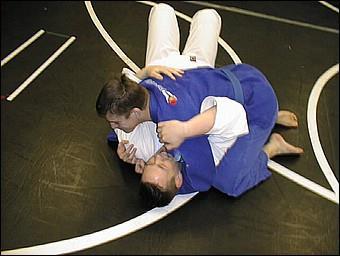Side Control One participant lies on top of their partner chest-to-chest, with their bodies aligned perpendicular to