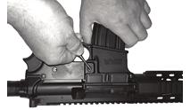 The action may be manually opened by pulling the charging handle rearward and pressing on the bottom of the bolt catch until the action catches and stays open (Fig. 9).