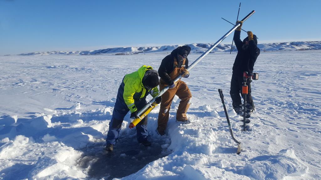 Fig. 7: The single-transponder deployment on the fixed ice was done with simple equipment, and using 3 m long poles.