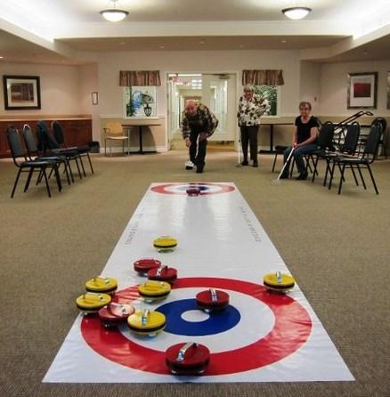 Pusher sticks, which allow participants, including those in wheelchairs, to easily deliver the floor curling rocks without bending to floor level, are used.