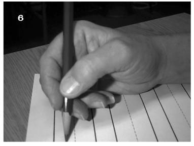 The pencil is simply slid between the thumb, index and middle finger (try to hold as high up as