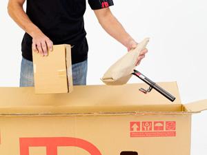 Begin by carefully cutting through the cardboard bike box with a sharp box cutter or a pair