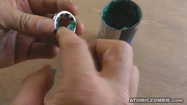 When lubricating a ball bearing that includes a retaining ring, fill the