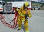Grasp nozzle with left hand. Rotate under hose placing over left shoulder with nozzle against chest.