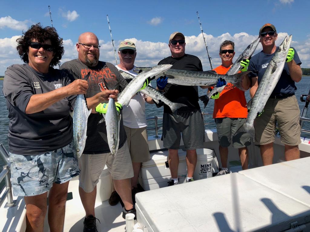Captain Kathy Brown of Miss Judy Charters is holding Spanish mackerel and the rest of the fishing team are holding as assorted sizes of barracuda!