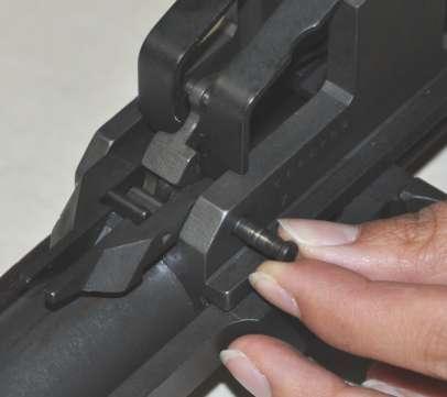 Compress the operating rod spring, and engage the forks of the follower rod with the front studs
