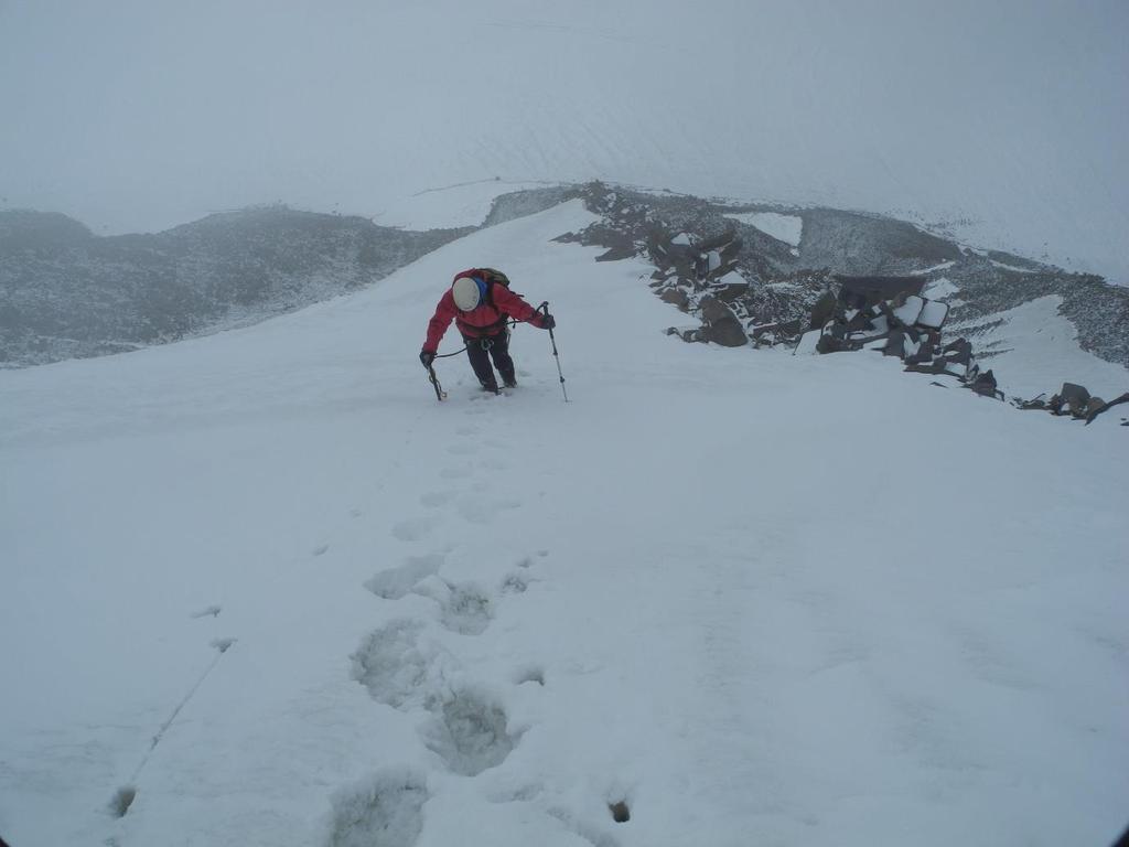 Figure 5: Climbing the snow and ice of the south face gulley [Photo: Keith Goffin]. We reached the first summit at about 11:30 but saw that the second, more westerly, summit appeared higher.