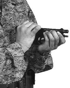 Pull the slide to the rear by pushing forward with the right thumb and pulling back on the rear sight with the fingers.