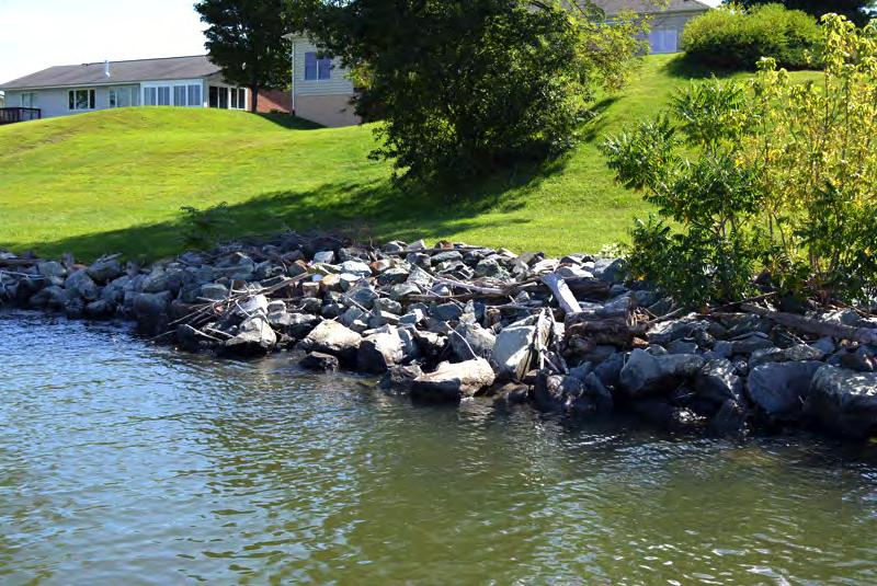A revetment is a facing of stone or other armoring material to protect a shoreline. A riprap revetment consists of layered, various-sized rocks placed on a sloping bank.