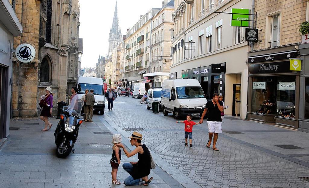 Shoppers walk along the rebuilt Rue Saint-Pierre in Caen, which was