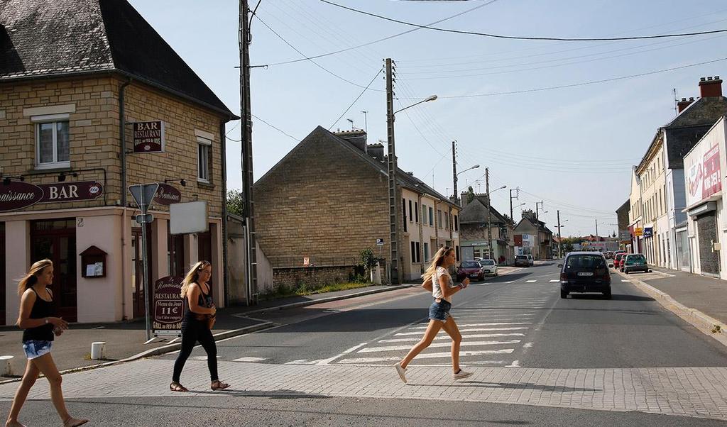 Girls run across the street at the junction of Rue Holgate and RN13 in