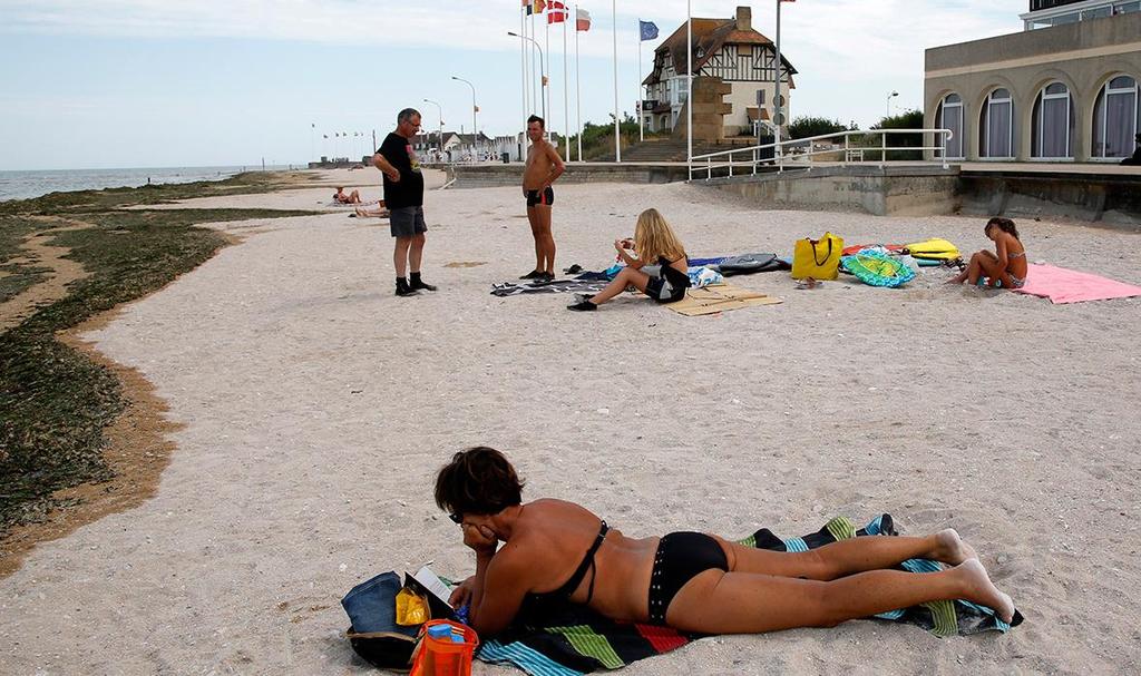 A tourist sunbathes on a former Juno Beach landing area where