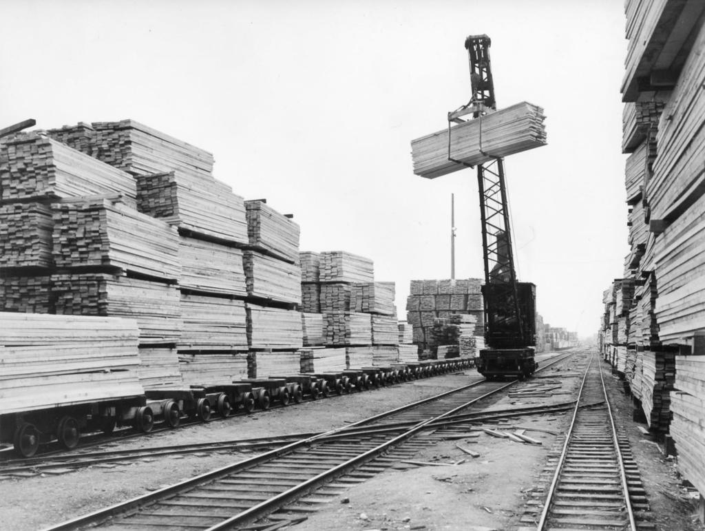 Mill B Gallery 10 Steam-powered standard gauge traveling crane hoists a stack of lumber at Mill B, circa 1940.