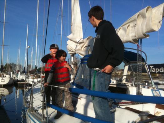 org ADAM SHOWS LITTLE GUYS THE ROPES Lucky Laird (grandson of former member Steve Laird) and Dylan Ordin get a lesson about sailing from Adam Helms.