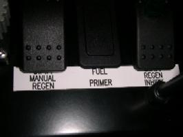 When a manual regeneration is called for, the control switches to perform the manual regeneration can be found under the pump shift PTO box on the lower left side of the steering column.