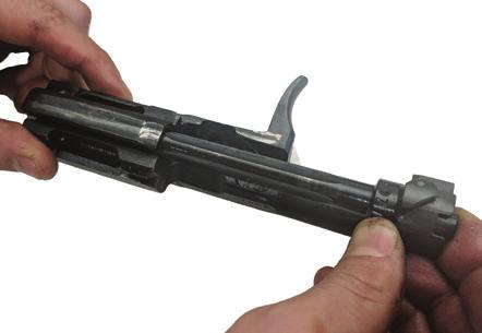 The rear end of the guide is inserted into the groove in the rear of the receiver by pressing the spring first forward and downward and then letting the guide move gently to the rear