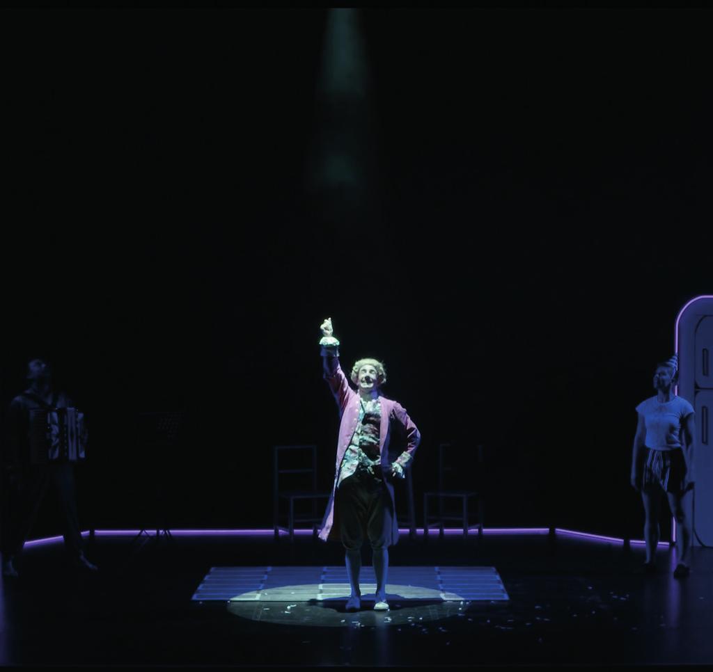 The woman and Wolfgang begin to play football with a spotlight. The light then gets kicked into the audience. The lights onstage will become quite dark, and the spotlight may shine in your eyes.