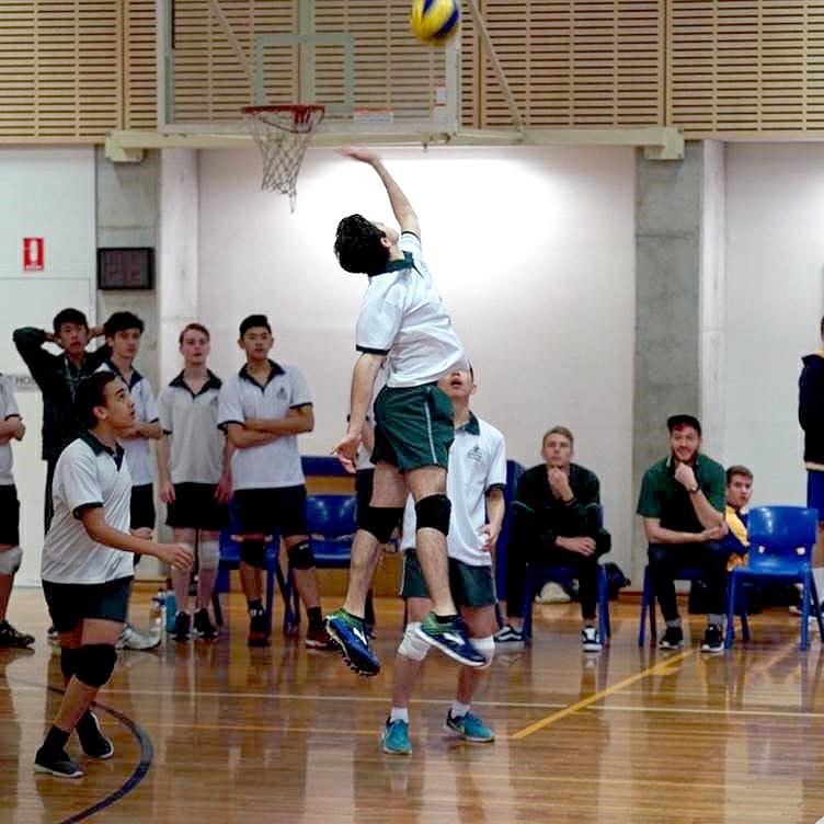 Alan Nader (10WJ) jumping high to spike the ball successfully against St