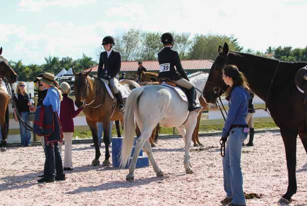 ABOVE: As volunteers help hold horses, riders find their mounts, adjust their stirrups and head into the ring for competition.